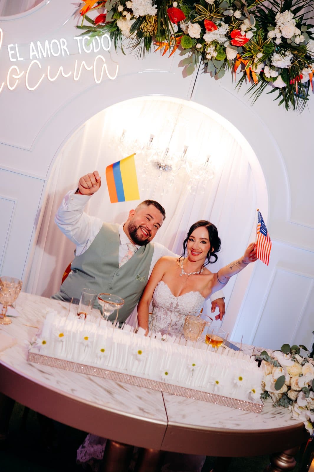 The couple raises the flags of Colombia and the United States at their head table
