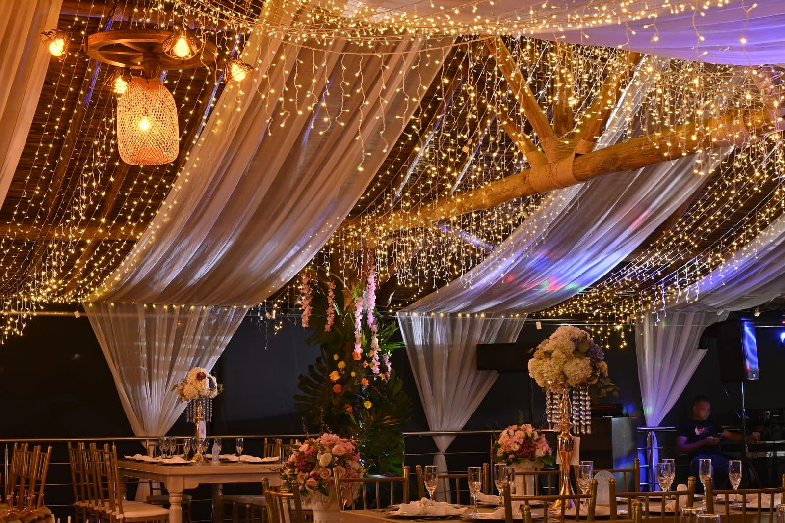 Salón de 15 años con techo de telas y luces cálidas